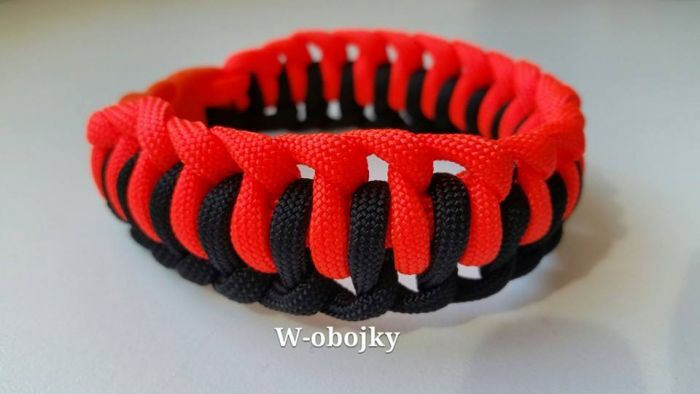Náramek, vzor "střídavý uzel" v oranžovo-černé kombinaci.